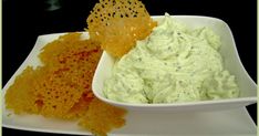 a white plate topped with guacamole and chips