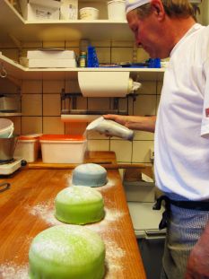 a man standing in a kitchen preparing food on top of a wooden counter next to an oven