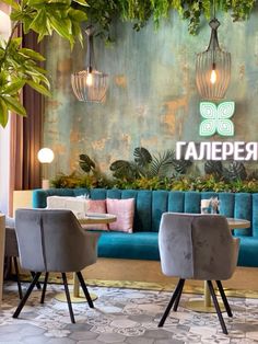 the restaurant is decorated with green plants and blue couches