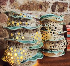 four ceramic vases sitting on top of a table next to a stack of books