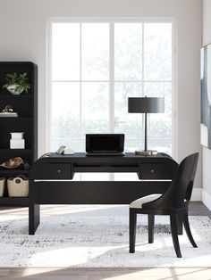 a black desk with a laptop on it in front of a bookcase and window