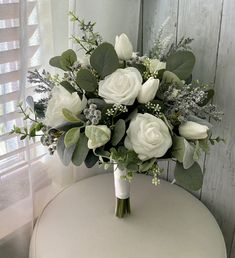 a bouquet of white flowers sitting on top of a table