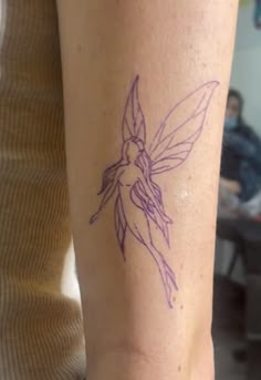 a woman's arm with a tattoo on it that has a purple fairy tail