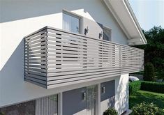 a house with a balcony and balconies on the outside, in front of some bushes