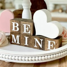 wooden blocks spelling the word be mine on a table