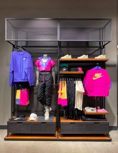 a display case filled with lots of different colored shirts and jackets on shelves next to each other