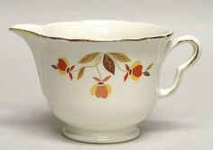 a white cup with orange and yellow flowers on it