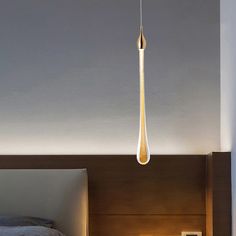 a bedroom with a bed and a light hanging from the ceiling