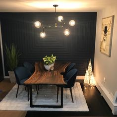 a dining room with black walls and white rug