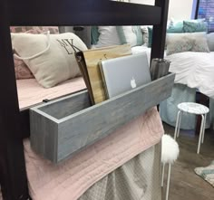 a bed with a laptop and other items in the bottom drawer on top of it