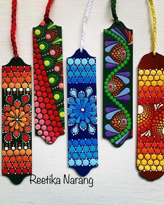 four colorful painted bookmarks hanging from strings on a white background with the words reetika naranig written below them