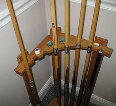 several wooden baseball bats lined up in a corner with the bat holders on each side