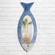 a blue and white vase shaped mirror hanging on a brick wall