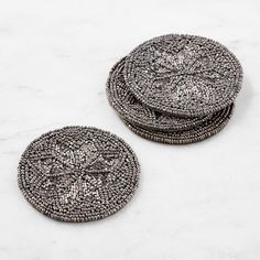 two silver buttons sitting on top of a white counter