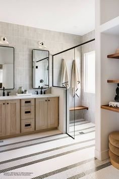 a bathroom with two sinks, mirrors and shelves in the wall next to each other