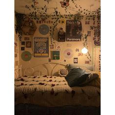 a bedroom with lots of pictures on the wall and decorations hanging above the bedspread