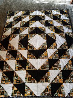 a black and white quilt is laying on the floor