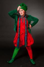 a woman dressed in red and green is posing for the camera with her hands on her head