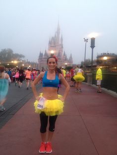 a woman standing in front of a castle wearing a yellow tutu skirt and red shoes