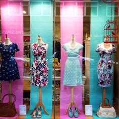 three mannequins dressed in dresses and purses on display at a store