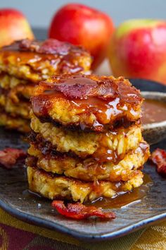 three pancakes stacked on top of each other with chocolate sauce and fruit in the background