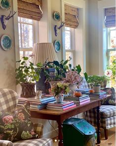 a living room filled with lots of furniture and flowers on top of a wooden table