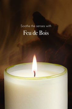 a lit candle with the words feu de bois written in french on it