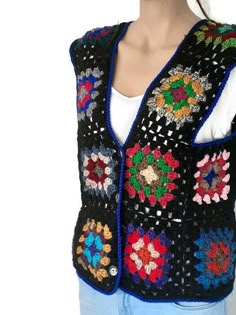 a woman wearing a black crocheted vest with multicolored flowers on it