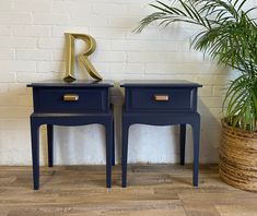 two blue nightstands sitting next to each other in front of a brick wall