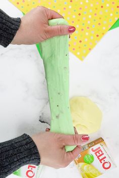 someone is making something green and yellow with their hands on top of the paper towel