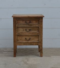 an old wooden dresser with three drawers on it's sides, against a white wall