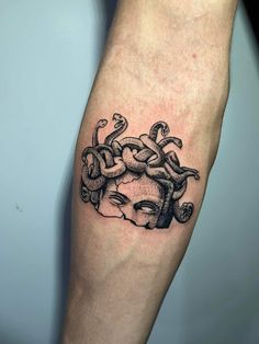 a man's arm with a black and white tattoo design on the left forearm