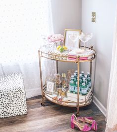 a gold bar cart with lots of bottles on it