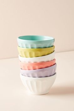 four bowls stacked on top of each other in different colors and sizes, one is empty