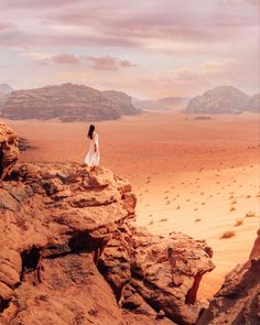 a woman standing on top of a rock formation in the desert