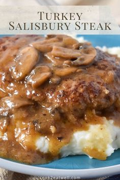 a blue plate topped with mashed potatoes covered in gravy