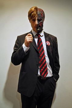 a man in a suit with a mask on his face