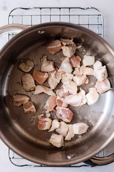 chicken and meat cooking in a pan on the stove