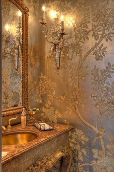 a bathroom with a sink, mirror and chandelier on the wall next to it