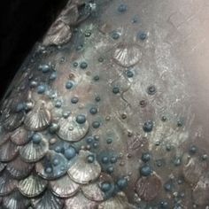 the back of a woman's dress covered in water droplets and seashells