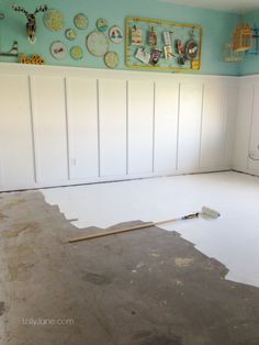 an empty room with white paneling and paint on the walls, including a floor that needs to be sanded down