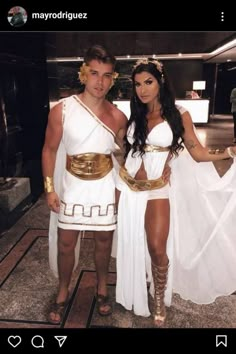 two people dressed in roman costumes posing for a photo with one person wearing a white dress and gold belt