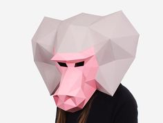 a woman wearing a paper mask with a pink gorilla face on it's head