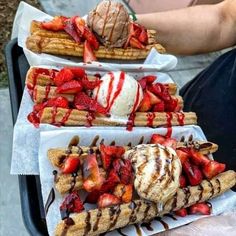 three waffles with ice cream and strawberries on them