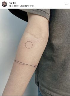 a woman's arm with a small circle tattoo on the left side of her arm