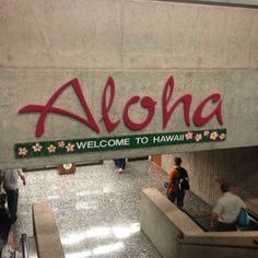 people are walking through an airport with the name aloha on it