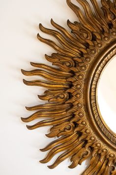 a mirror that is on the wall with an artistic design in it's center