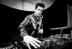 a man that is standing in front of a dj's turntable and mixing equipment