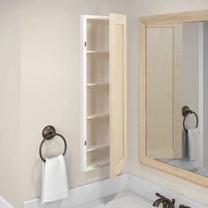 a bathroom sink sitting under a mirror next to a towel dispenser on a wall