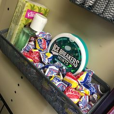 a basket filled with assorted candy and other items on top of a shelf in a room